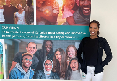 Women standing next to QCH banner